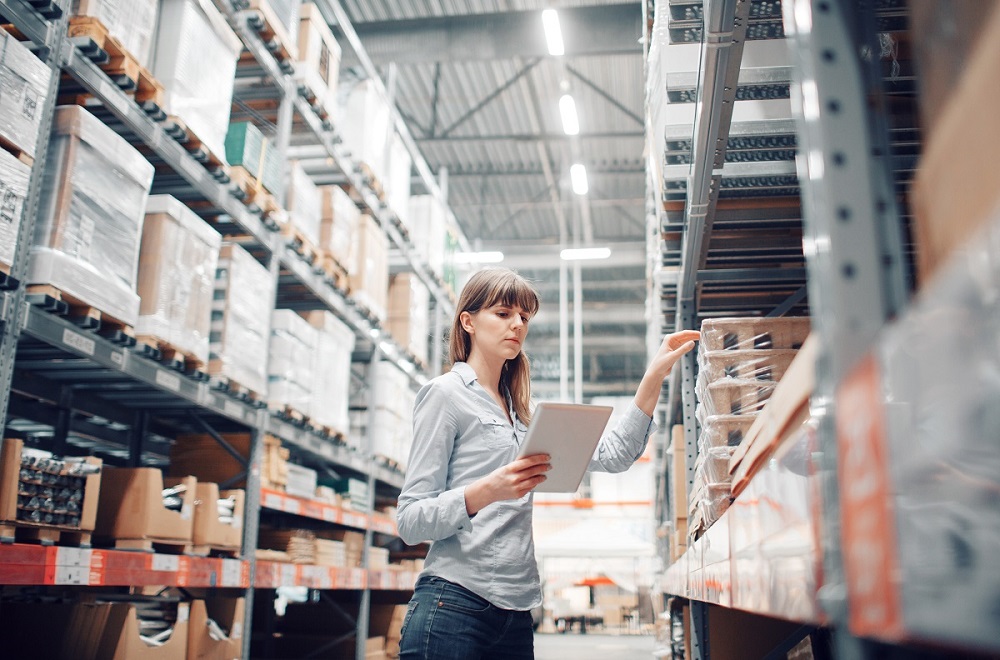 Woman in polo auditing a warehouse