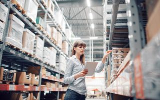 Woman in polo auditing a warehouse